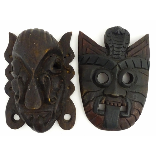 1170 - Ethnographic / Native / Tribal : Two African carved wooden masks, both with teeth bared and tongue o... 