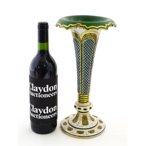 304 - A Bohemian green glass vase of flared form with white overlay and gilt detail. Approx. 12 1/4