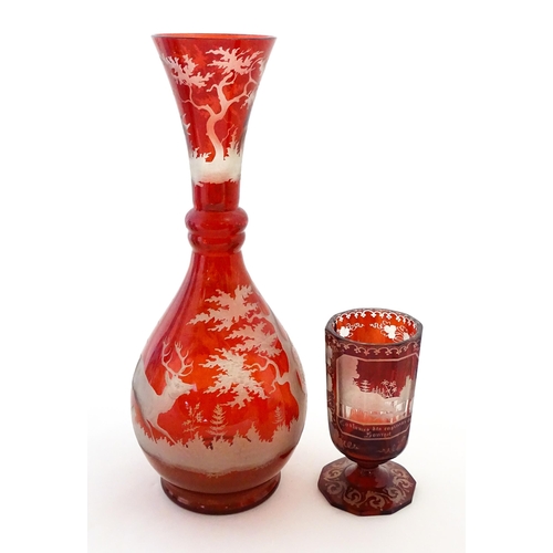 306 - A Bohemian red glass carafe / vase with etched stag decoration. Together with a French ruby glass go... 
