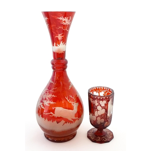 306 - A Bohemian red glass carafe / vase with etched stag decoration. Together with a French ruby glass go... 