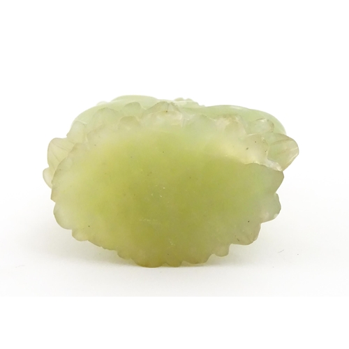 1023 - A Chinese jade coloured soapstone carving modelled as a seated Buddha with hands in prayer on a styl... 