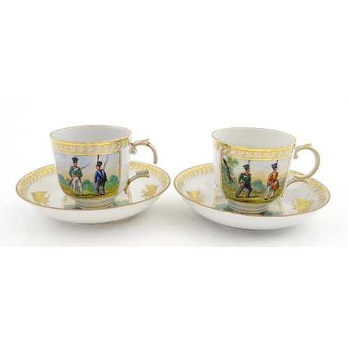 222 - Two Polish Korzec tea cups and saucers with hand painted decoration depicting 18thC Infantry soldier... 