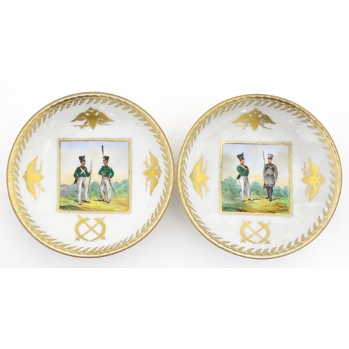 222 - Two Polish Korzec tea cups and saucers with hand painted decoration depicting 18thC Infantry soldier... 