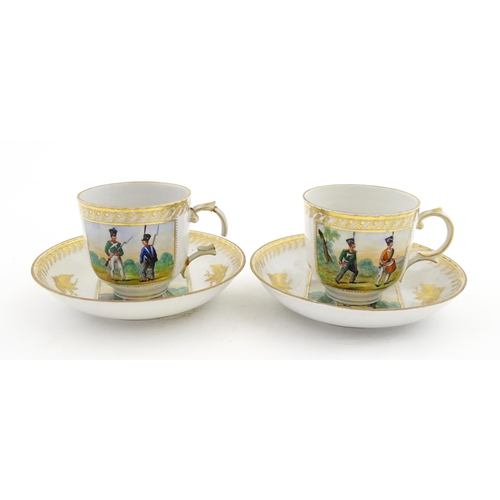 222 - Two Polish Korzec tea cups and saucers with hand painted decoration depicting 18thC Infantry soldier... 