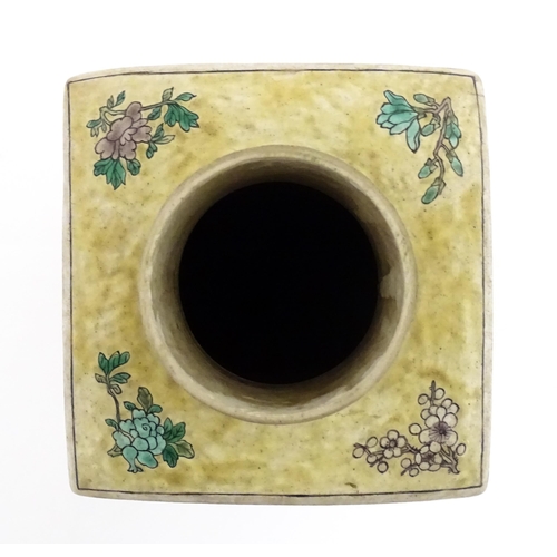 226 - A Chinese vase of squared form with a yellow ground decorated with blossom, peonies, lotus leaves, b... 