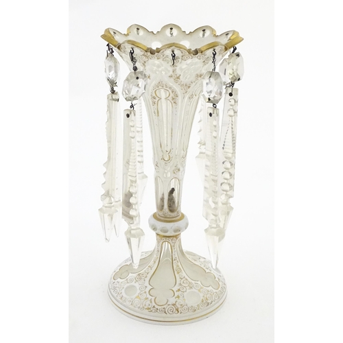 314 - A Victorian glass table lustre with white overlay and gilt detail with glass lustre drops. Approx. 1... 