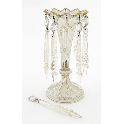 314 - A Victorian glass table lustre with white overlay and gilt detail with glass lustre drops. Approx. 1... 