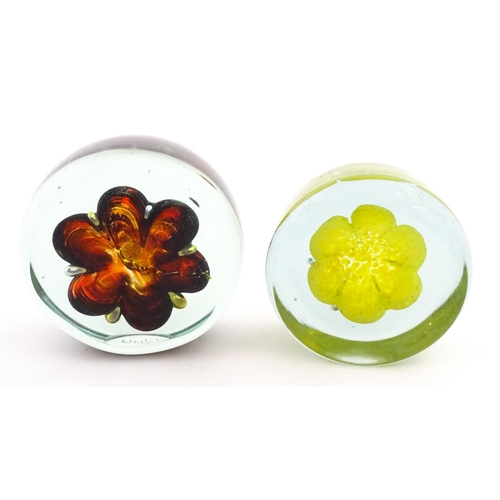 331 - Two Mdina glass paperweights with flower detail. Both signed under. Largest approx. 4 1/2