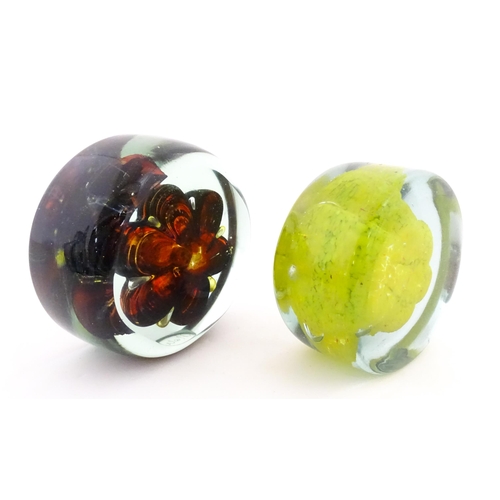 331 - Two Mdina glass paperweights with flower detail. Both signed under. Largest approx. 4 1/2