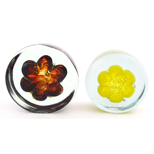 331 - Two Mdina glass paperweights with flower detail. Both signed under. Largest approx. 4 1/2