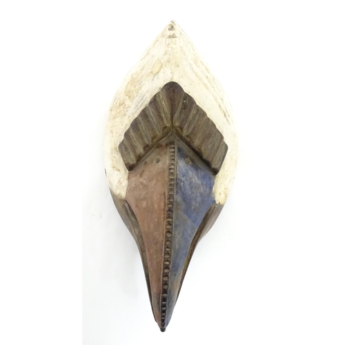 1180 - Ethnographic / Native / Tribal : An African bird mask with polychrome detail. Approx. 13 1/2