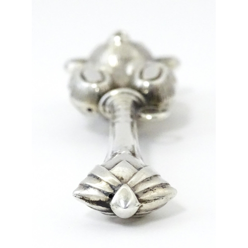 351 - A white metal child's rattle with teddy bear decoration. Approx. 4 1/2