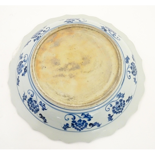 63 - A Chinese blue and white charger decorated with ducks and lotus flowers with scrolling foliate borde... 