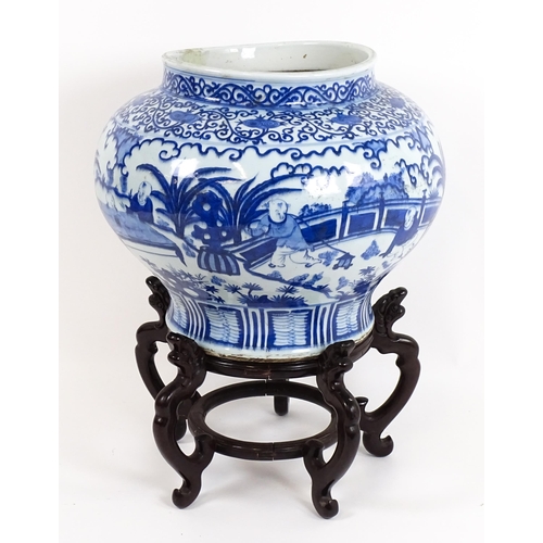 62 - A large Chinese blue and white jardiniere of bulbous form decorated with figures in a garden landsca... 