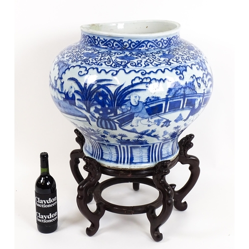 62 - A large Chinese blue and white jardiniere of bulbous form decorated with figures in a garden landsca... 