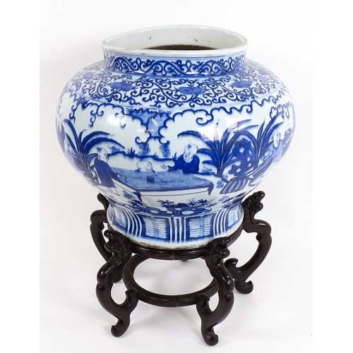62 - A large Chinese blue and white jardiniere of bulbous form decorated with figures in a garden landsca... 