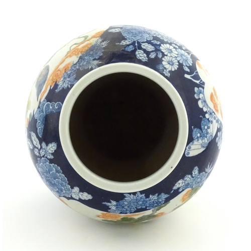 20 - A Chinese blue and white vase with carved hardwood lid, decorated with flowers and butterflies with ... 