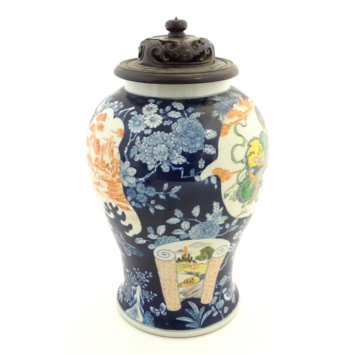 20 - A Chinese blue and white vase with carved hardwood lid, decorated with flowers and butterflies with ... 