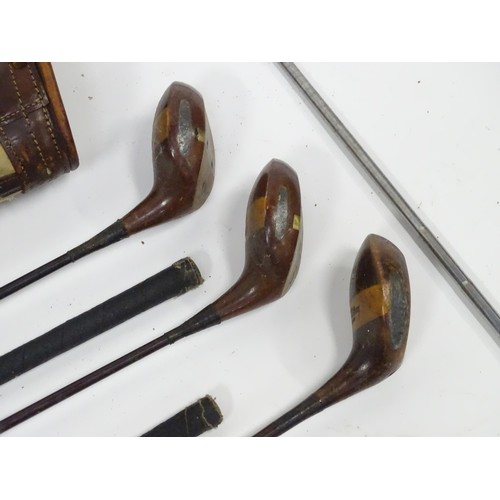 8 - A mid 20thC golf bag and clubs, including three hardwood drivers stamped 'Fred Whitting - Sandwich',... 