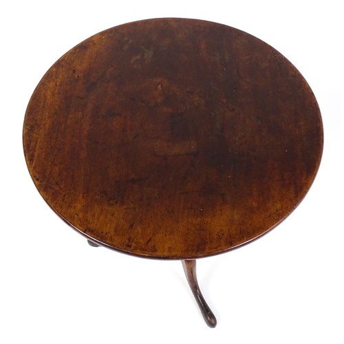 25 - A Georgian mahogany tripod table with a circular top above a turned pedestal and raised on three cab... 