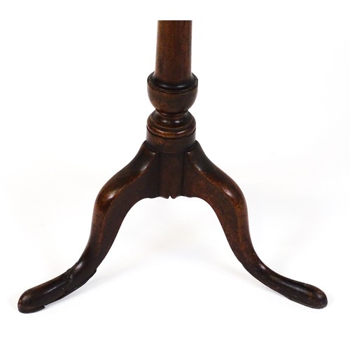 25 - A Georgian mahogany tripod table with a circular top above a turned pedestal and raised on three cab... 