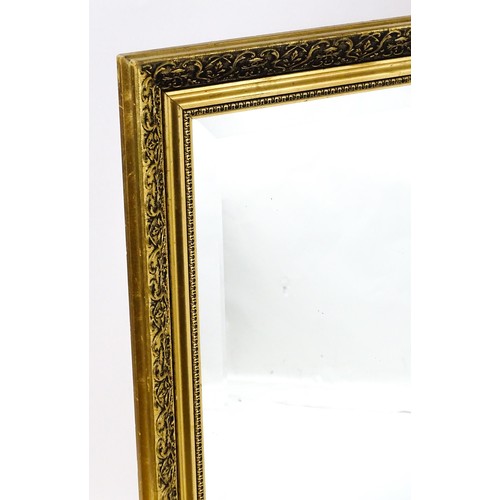 32 - A modern mirror with a gilt moulded frame and bevelled glass centre. 52
