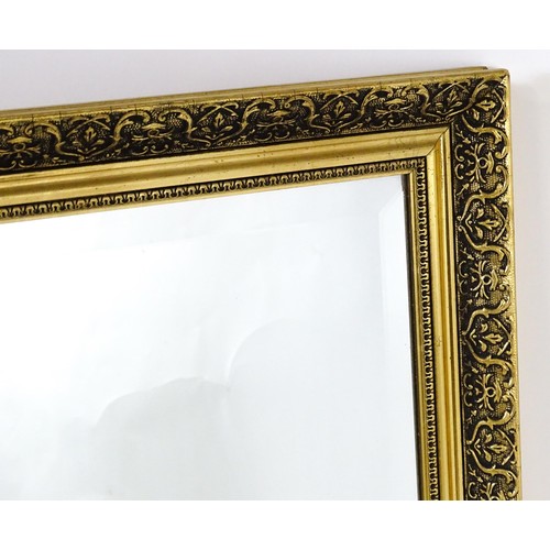 32 - A modern mirror with a gilt moulded frame and bevelled glass centre. 52