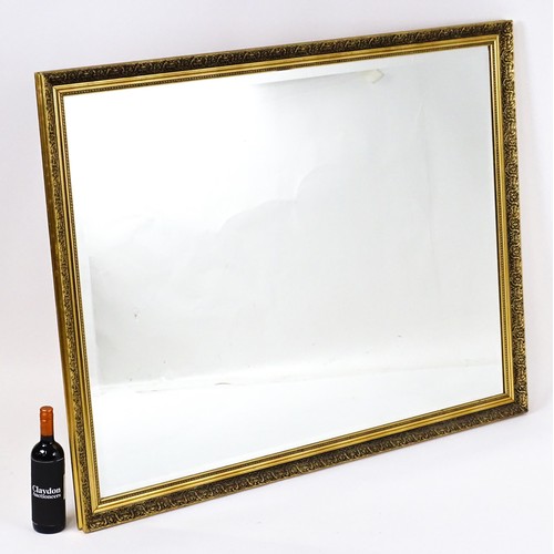 32 - A modern mirror with a gilt moulded frame and bevelled glass centre. 52