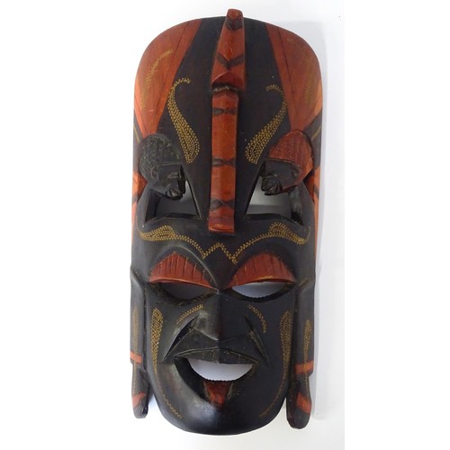 59 - Ethnographic / Native / Tribal : Three African carved masks with painted detail. Together with a car... 