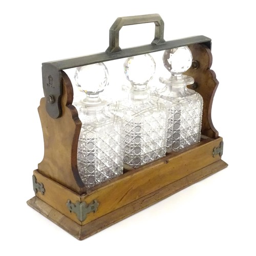 An walnut Betjemann’s patent Tantalus titled 'The Tantalus' with three glass decanters. Approx. 13" wide