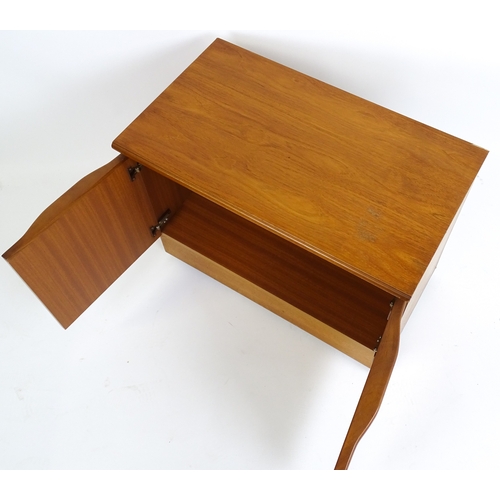 21 - Vintage / Retro: A teak two door cabinet raised on castors. 29 1/2