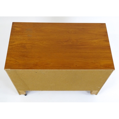 21 - Vintage / Retro: A teak two door cabinet raised on castors. 29 1/2