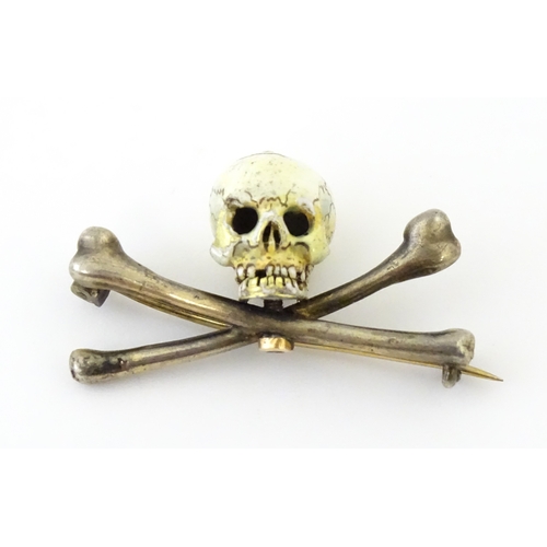 A white and yellow metal brooch / pin formed as a skull and crossbones. The skull with enamel detail. In the manner of French jeweller Auguste-Germain Cadet-Picard. Approx. 1 1/4" wide