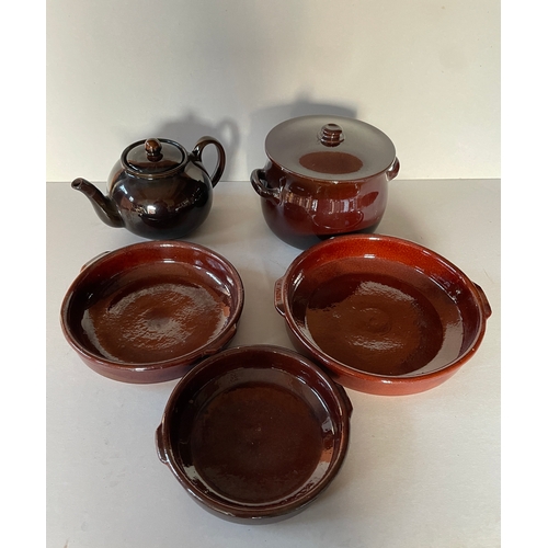 117 - A quantity of brown glazed ceramics - flan dishes, teapot and casserole dish. Largest dish 18 cms di... 
