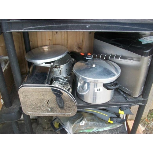 85 - A shelf of stainless steel kitchen ware