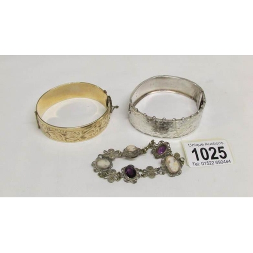 1025 - A silver bangle, a gold plated bangle and a cameo bracelet