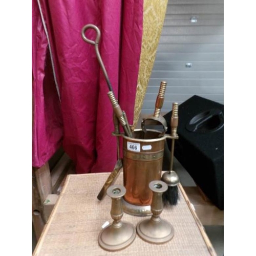 466 - A brass and copper companion set and a pair of brass candlesticks