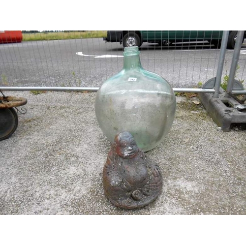 342 - A large bulbous glass vase and a garden Buddha