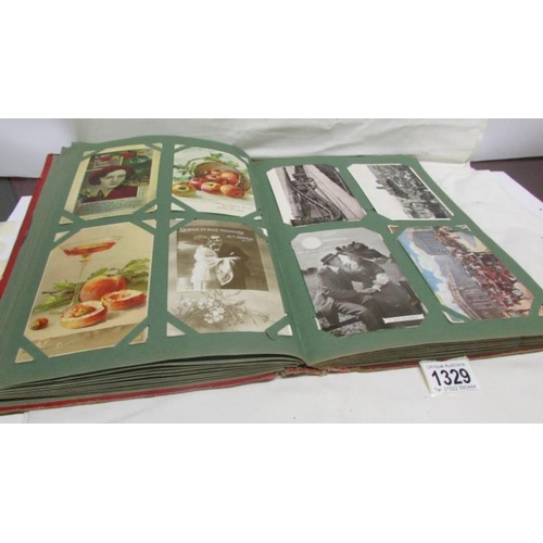 1329 - A red postcard album containing in excess of 250 postcards including Landscapes, Bamforth, Greeting ... 