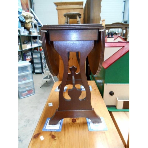 454 - A darkwood drop leaf table with leather seats