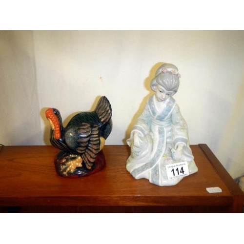 114 - A turkey figurine money box and a Geisha figurine