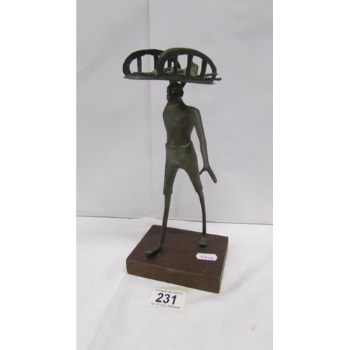 231 - A brass tribal figure carrying a boar