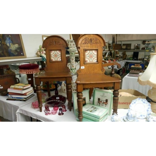 357 - A pair of late 19th century oak hall chairs with tile inset in back