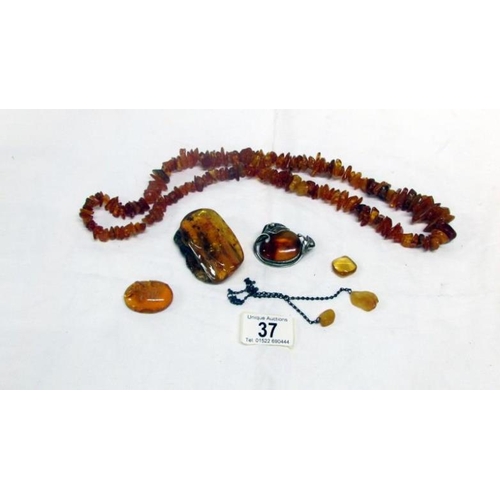 37 - An amber necklace, 2 amber brooches including one in silver mount and 4 pieces of amber