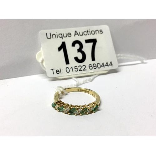 137 - An emerald diamond band ring in 18ct gold, size L