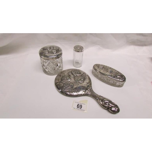 69 - A silver backed hand mirror and 3 silver topped pots all embossed with cherubs, maker W J Myatt, Bir... 