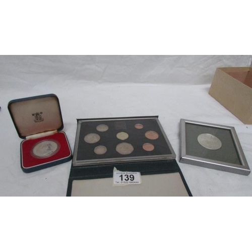 139 - A set of 1983 coins, a 1978 Guernsey 5/- piece and a framed Southwell Minster medallion