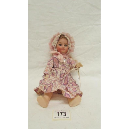 173 - A porcelain headed doll with plastic body