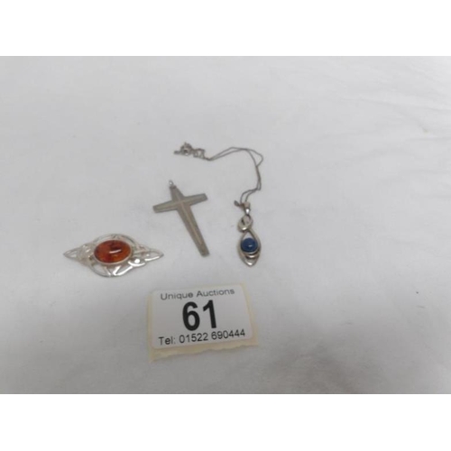 61 - A silver pendant on chain, a silver cross and a silver brooch set amber