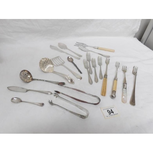 94 - A mixed lot cutlery including sifter spoons, pickle forks, sugar tongs etc